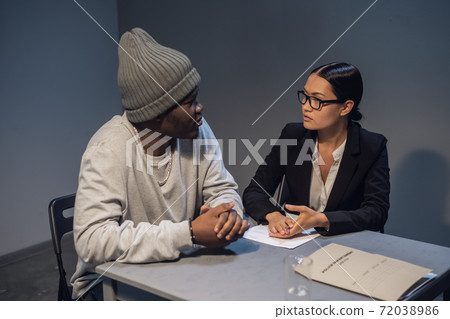 A beautiful female lawyer offers a defense strategy to her client accused of drug distribution A beautiful female lawyer offers a defense strategy to her client accused of drug distribution 72038986