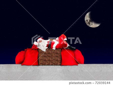 Santa Claus lying on the chimney at a snowy roof with large bags full of Xmas gifts Santa Claus lying on the chimney at a snowy roof with large bags full of Xmas gifts 72039144