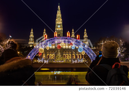 A tourists take pictures on the Christmas market in night Vienna, Austria. A tourists take pictures on the Christmas market in night Vienna, Austria. 72039146