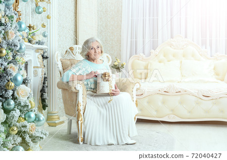 Happy smiling senior woman posing with gift 72040427