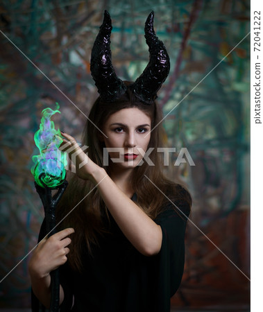 Maleficent demonic. young pretty dressed as a fairy with horns and magic ball 72041222