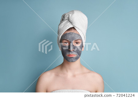 teenage girl with clay mask on the face blue background teenage girl with clay mask on the face blue background 72041224
