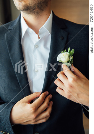 Morning groom, Groom in a jacket, The groom straightens the buttonhole, wedding day Morning groom, Groom in a jacket, The groom straightens the buttonhole, wedding day 72041499