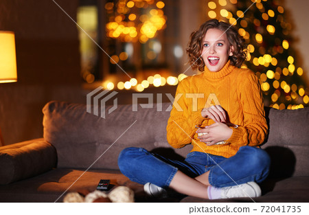 Excited female eating popcorn and watching film 72041735