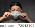 Healthy woman using medical protective mask to health protection 72042309