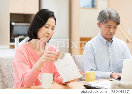 Middle couple looking up drug information Middle couple looking up drug information 72044857