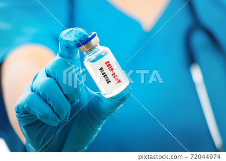 woman doctor in blue uniform holding COVID-19 vaccine woman doctor in blue uniform holding COVID-19 vaccine 72044974