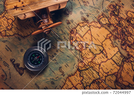 Old compass discovery and wooden plane on vintage paper antique world map Old compass discovery and wooden plane on vintage paper antique world map 72044997