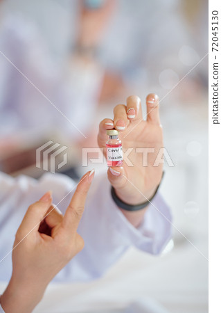 Female scientist showing vaccines Female scientist showing vaccines 72045130