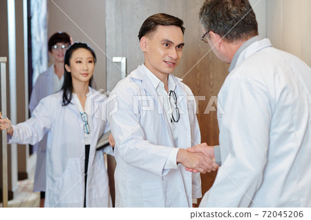 Doctor talking to experienced colleague 72045206