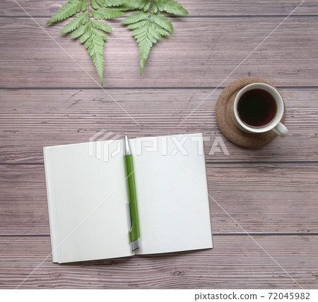 Open notepad with pen, coffee and green plants on wood table. Open notepad with pen, coffee and green plants on wood table. 72045982
