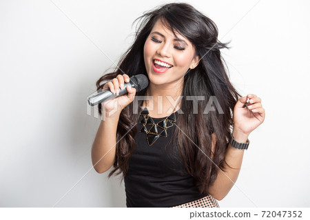 Pretty young asian woman happy singing a song Pretty young asian woman happy singing a song 72047352