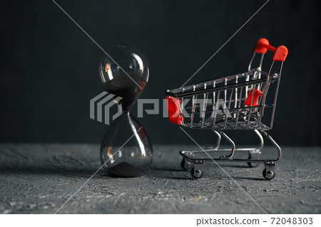 Time for shopping concept. Shopping cart and hourglass. Sale Time for shopping concept. Shopping cart and hourglass. Sale 72048303