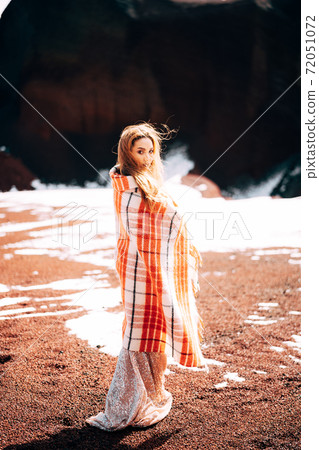 Portrait of a bride model in a golden wedding evening dress, in a yellow-red sandy quarry, in the crater of a volcano in Iceland, Golden Circle. Portrait of a bride model in a golden wedding evening dress, in a yellow-red sandy quarry, in the crater of a volcano in Iceland, Golden Circle. 72051072