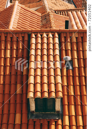 Small windows on the attic floor, in a brown tiled roof. 72051402