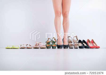 Woman chooses classic black heeled shoes. 72051974