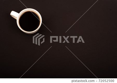 Top view of white ceramic mug with black coffee on black background. Copy space Top view of white ceramic mug with black coffee on black background. Copy space 72052500