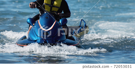 Lifeguard on a jet ski patrols the beach an ocean safety lifeguard riding a jet ski Lifeguard on a jet ski patrols the beach an ocean safety lifeguard riding a jet ski 72053031
