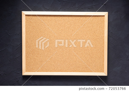 cork board and table near concrete wall 72053766
