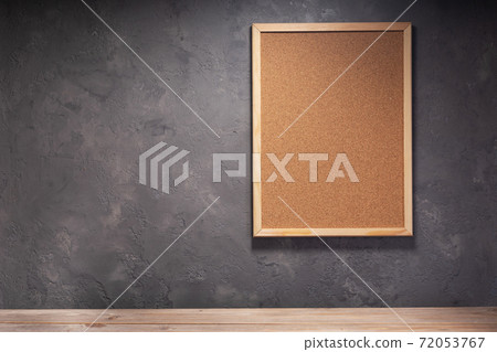 cork board and table near concrete wall 72053767