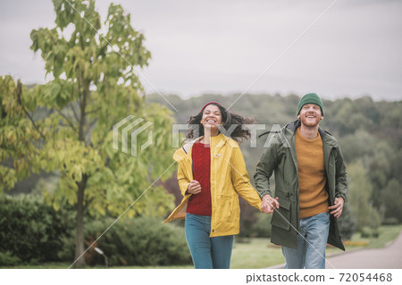 Young couple walking in the park and looking happy 72054468