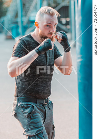 Street Fighter Boxing in Punching Bag Outdoors 72054477
