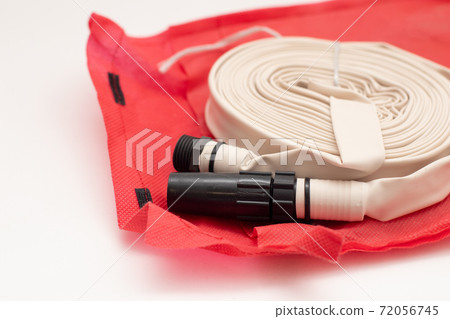 Rolled up firefighter hose reel on red bag Rolled up firefighter hose reel on red bag 72056745