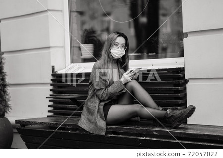 Young asian woman wearing face mask is standing at a domestic street. New normal covid-19 epidemic Young asian woman wearing face mask is standing at a domestic street. New normal covid-19 epidemic 72057022