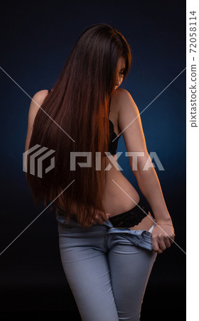 Photo of undressing girl on dark blue background Photo of undressing girl on dark blue background 72058114