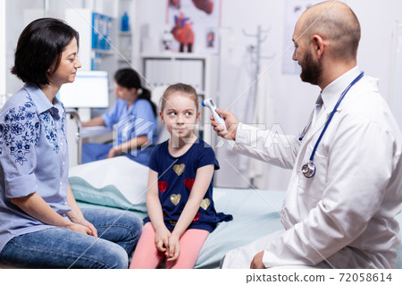 Doctor using digital thermometer Doctor using digital thermometer 72058614