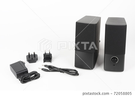 Two computer speakers on white background.  AC adapter with European plug and American plug  and audio cable. 72058805