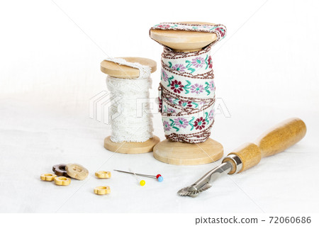 兩根綁在繩子上的鞋帶,扣眼針,木質鈕扣,輪盤和復制空間 兩根綁在繩子上的鞋帶,扣眼針,木質鈕扣,輪盤和復制空間 72060686