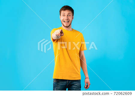 Happy male pointing finger at camera at studio 72062609