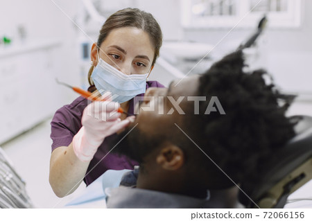 African patient in dentistry sitting in dental chair 72066156