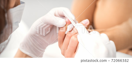 Manicurist filing the female nails 72066382