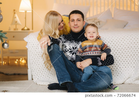Young family spend time at home in Christmas time. Happy Mom, dad and son enjoyng love hugs, holidays people. Togetherness concept 72066674