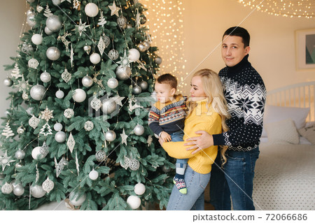 Young family spend time at home in Christmas time. Happy Mom, dad and son enjoyng love hugs, holidays people. Togetherness concept Young family spend time at home in Christmas time. Happy Mom, dad and son enjoyng love hugs, holidays people. Togetherness concept 72066686