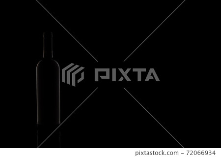 Wine bottle silhouette isolated on dark background. Studio photography. Wine bottle silhouette isolated on dark background. Studio photography. 72066934