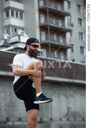 Bearded athletic man doing workout exercise in the outdoor gym in sunset Bearded athletic man doing workout exercise in the outdoor gym in sunset 72067110