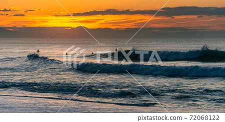 Surfers at sunset in Biarritz, France Surfers at sunset in Biarritz, France 72068122