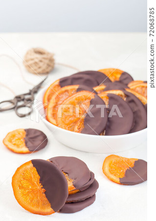 Homemade candied sliced oranges covered with chocolate, vertical Homemade candied sliced oranges covered with chocolate, vertical 72068785