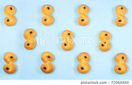Pattern with traditional Swedish and scandinavian Christmas saffron buns Lussekatter on blue backgroung, horizontal, top view 72068848