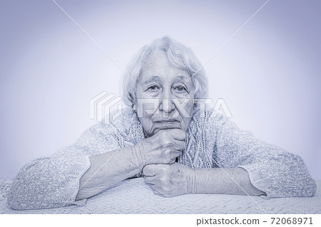 The sad senior grey haired woman dreaming on gray 72068971