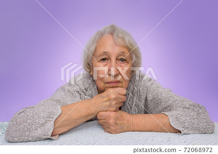 Senior grey haired woman dreaming isolated on blue background Senior grey haired woman dreaming isolated on blue background 72068972
