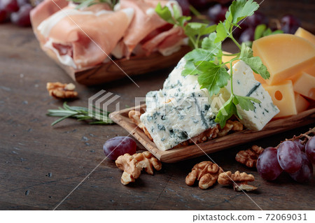 Various cheeses , grapes and prosciutto . Various cheeses , grapes and prosciutto . 72069031