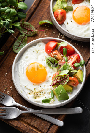 Fried egg with tomato avocado salad 72069624
