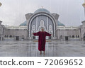 Inspired man in red looking up to the sky with arms outstretched sides 72069652