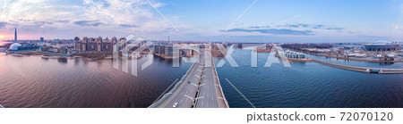 Aerial Panoramic view to evening St. Petersburg and Cable-stayed bridge across Petrovsky fairway. Western high-speed diameter WHSD at sunset. Modern highway along Neva river in a summer day. Russia. Aerial Panoramic view to evening St. Petersburg and Cable-stayed bridge across Petrovsky fairway. Western high-speed diameter WHSD at sunset. Modern highway along Neva river in a summer day. Russia. 72070120