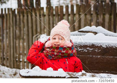 Winter girl throwing snowball at camera smiling happy having fun outdoors on snowing winter day playing in snow. Cute playful girl outdoor enjoying first snow Winter girl throwing snowball at camera smiling happy having fun outdoors on snowing winter day playing in snow. Cute playful girl outdoor enjoying first snow 72070450