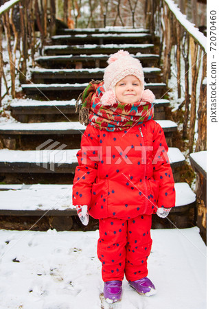 Winter outdoor portrait of adorable dreamy baby girl in knitted hat and scarf Winter outdoor portrait of adorable dreamy baby girl in knitted hat and scarf 72070460